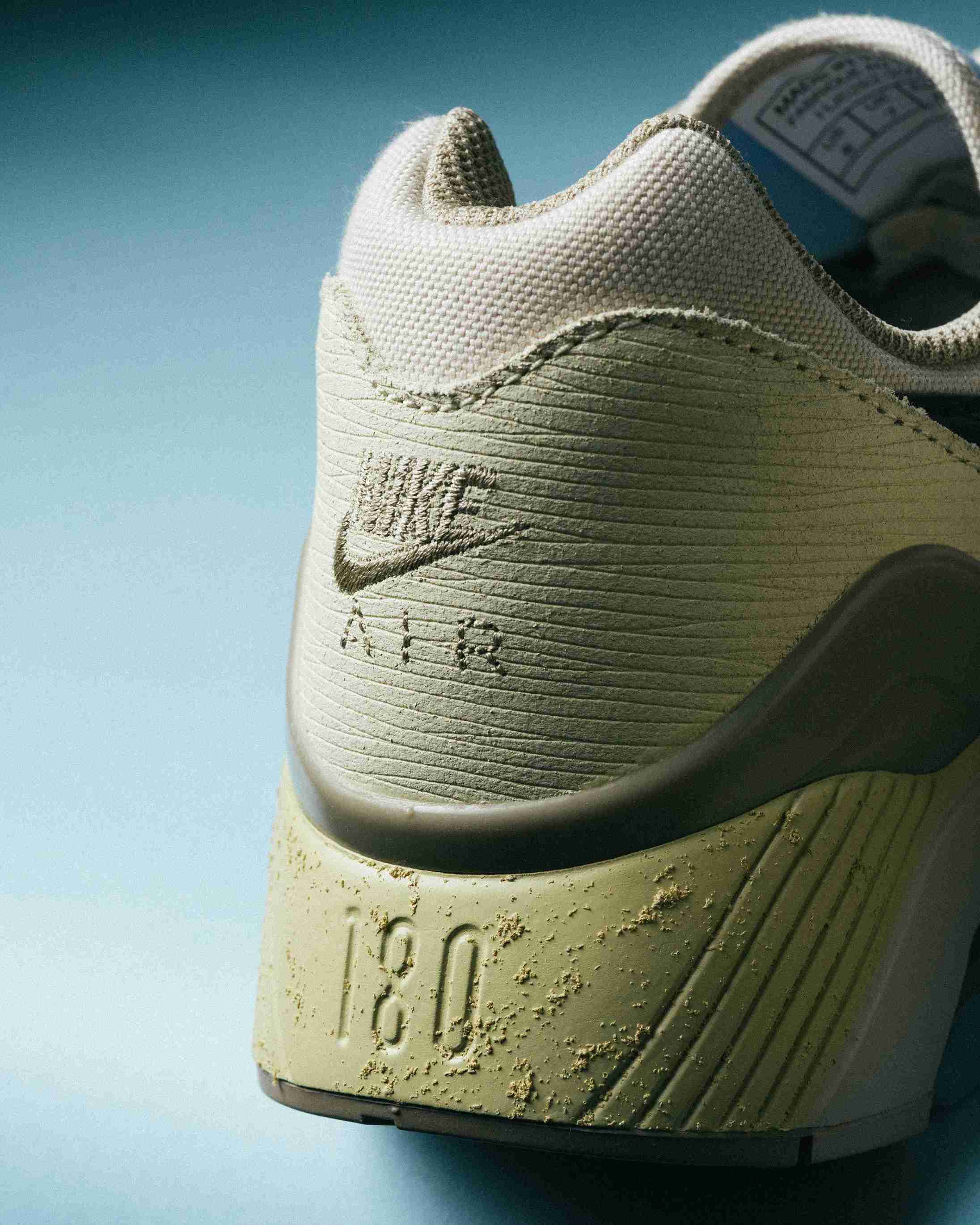 Paire de sneakers beige et bleu clair posée sur un fond bleu, vue de trois quarts avec mise en avant des formes et détails du modèle.